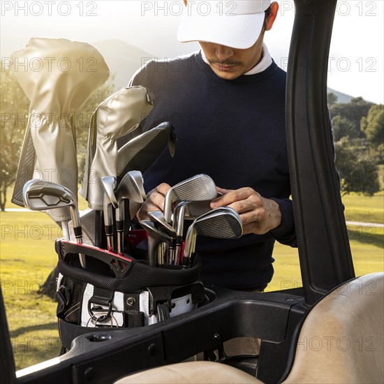 Man putting clubs golf cart