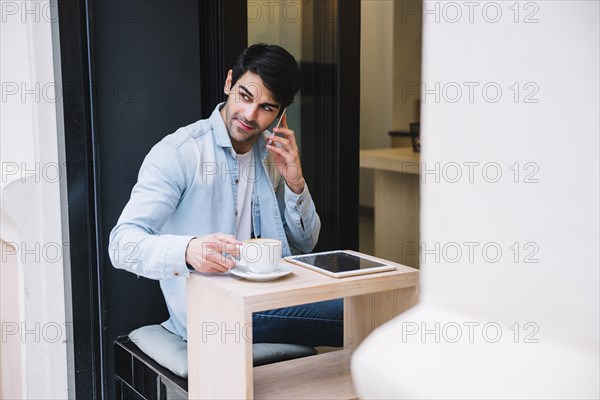 Man talking smartphone sitting cafe