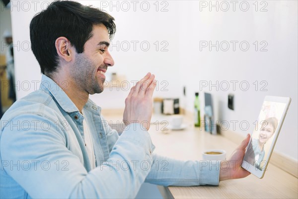 Man talking with little child using tablet