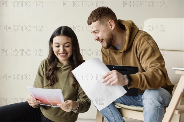 Medium shot couple holding plans