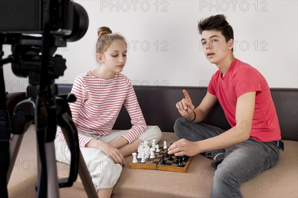 Medium shot friends playing chess