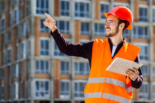 Medium shot portrait smiling architect pointing away