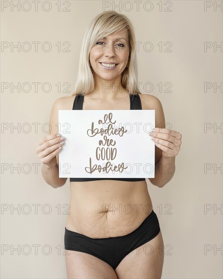 Medium shot smiley woman holding paper