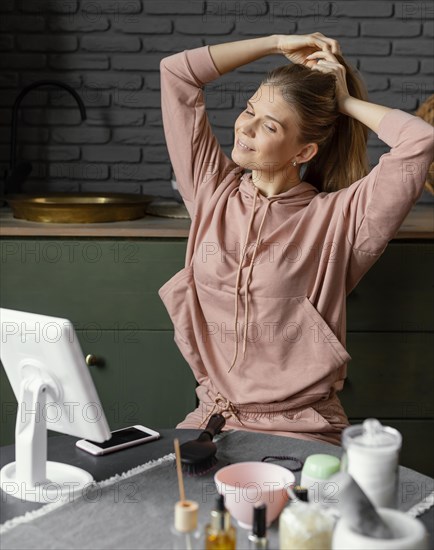 Medium shot smiley woman tying her hair