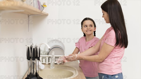 Mother girl washing hands