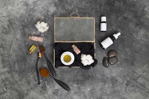 Open box with honey pink himalayan salt cotton bud with cosmetics products concrete black background