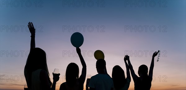 People dancing rooftop party dawn