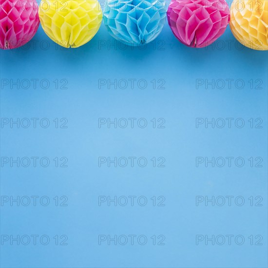 Pink yellow honeycomb pom pom paper balls decoration blue background