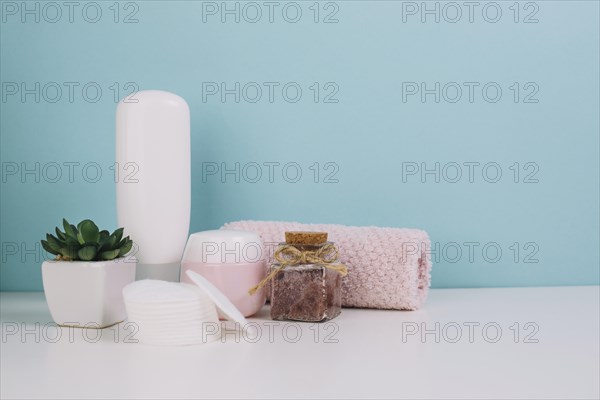 Plant cosmetics bottles near towel cotton pads