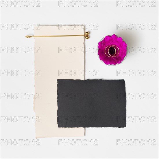 Set papers near fresh flower with rings plate