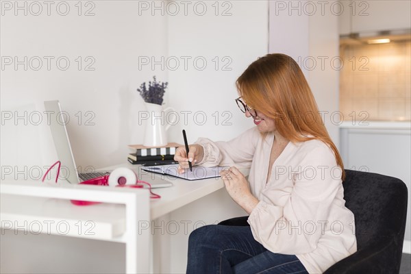 Side view female teacher during online class desk