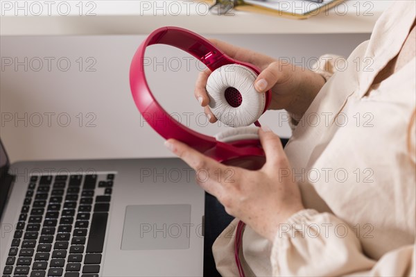 Side view female teacher holding headphones laptop online class