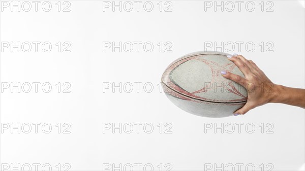 Side view hand holding rugby ball with copy space