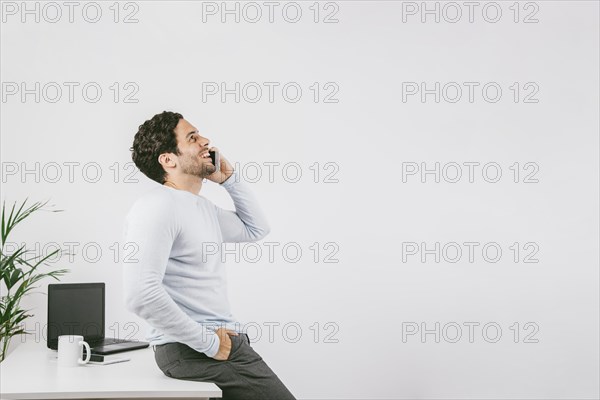 Smiley young man office talking phone