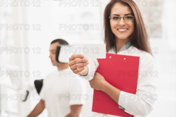 Smiling female doctor showing card mock up