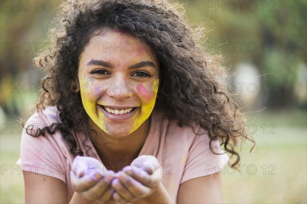 Smiling woman holding powdered paint her hands