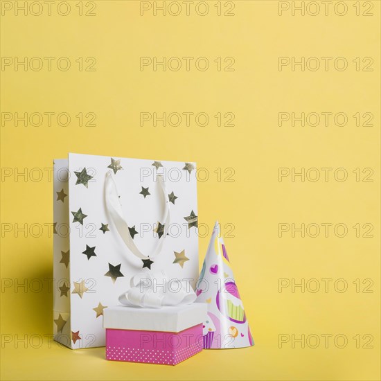 Star shape shopping bag paper hat gift box yellow background
