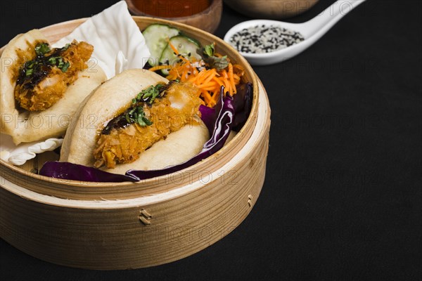 Steamed sandwich bamboo steamer with salad black background