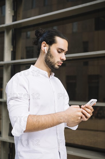 Stylish businessman texting message smartphone outdoors