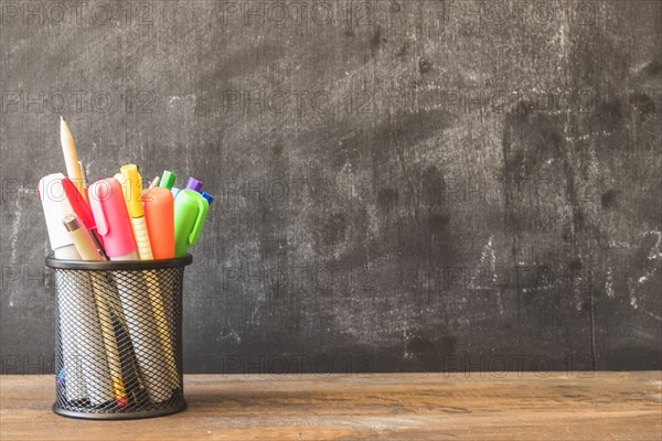 Table with pencil cup near blackboard