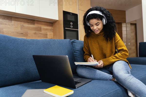 Teenage girl with laptop headphones during online school