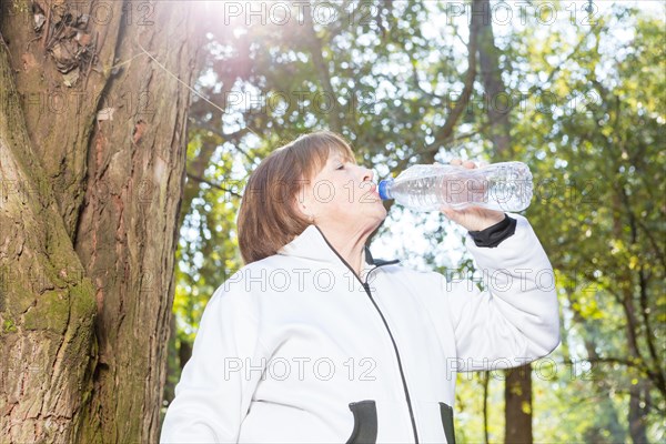 Thirsty woman drinking water sunny day