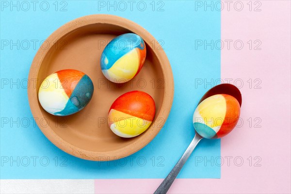 Top view colored eggs easter plate with spoon