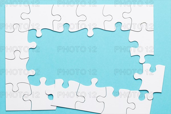 Top view incomplete puzzle frame blue backdrop