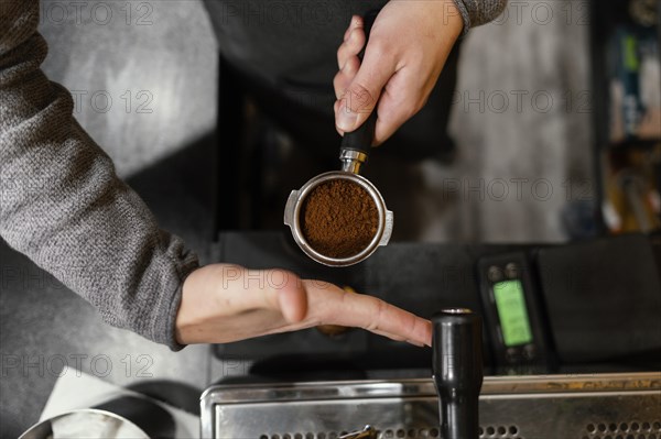 Top view male barista holding professional coffee machine cup