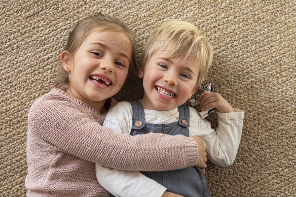 Top view young siblings hugging