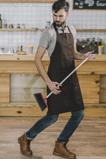 Waiter dancing with broom