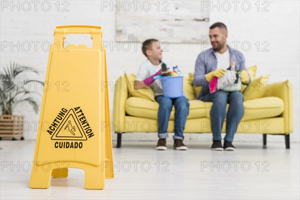 Wet floor sign with defocused father son