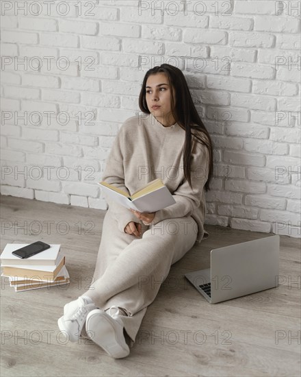 Woman floor with book laptop