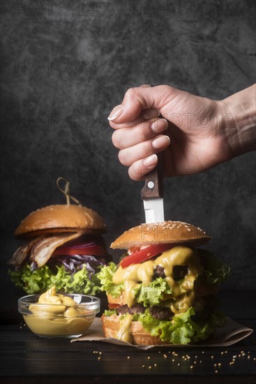 Woman holding knife tasty hamburger