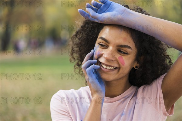 Woman smiling with hands covered blue powder