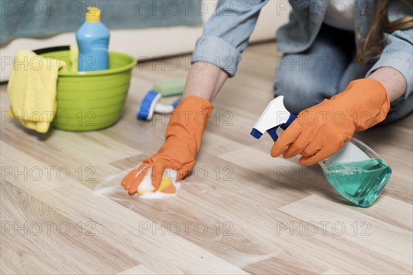 Woman with rubber gloves cleaning floors