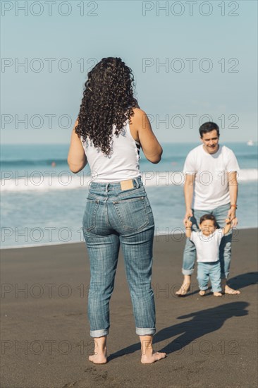 Young parents playing with baby beach