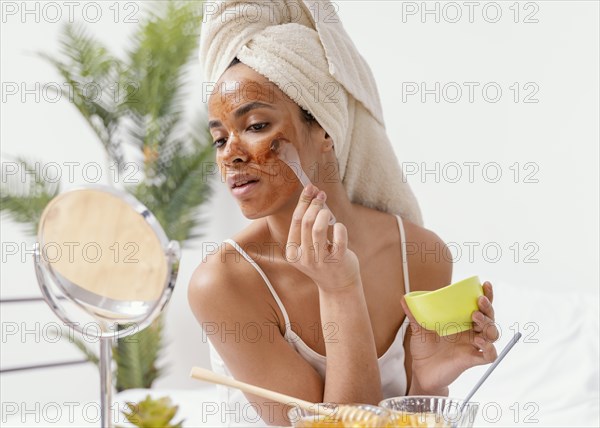 Young woman applying natural face mask