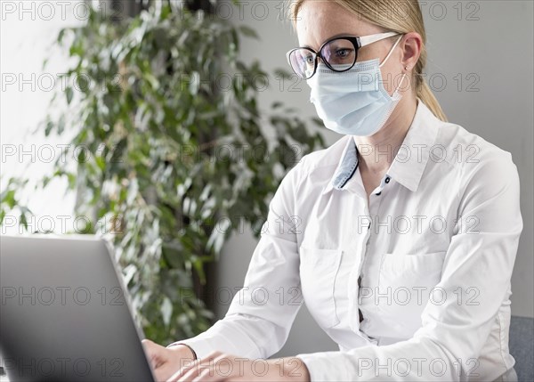 Young woman doing her classes while wearing face mask