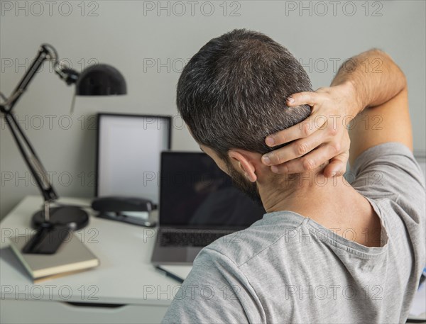 Back view man stretching while working from home