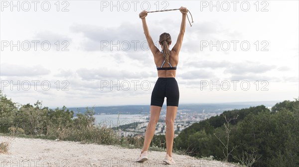 Back view woman holding rope up