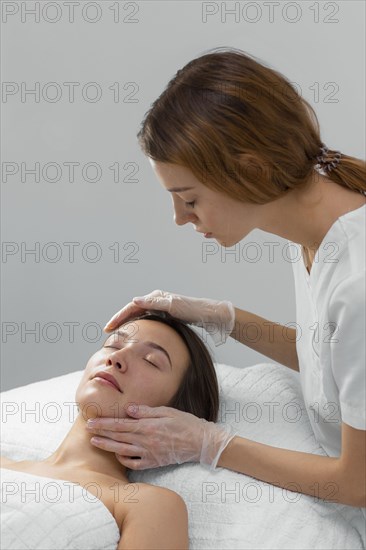 Beautician with female client salon face care routine 5