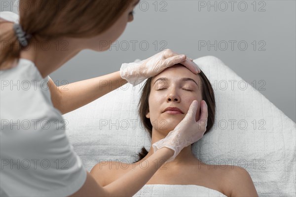 Beautician with female client salon face care routine 6