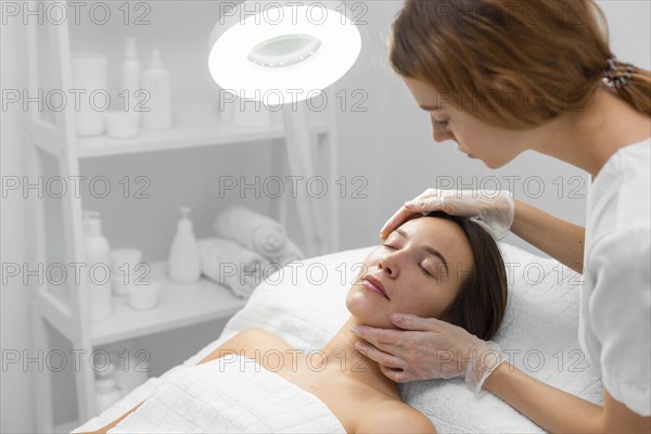 Beautician with female client salon face care routine 8