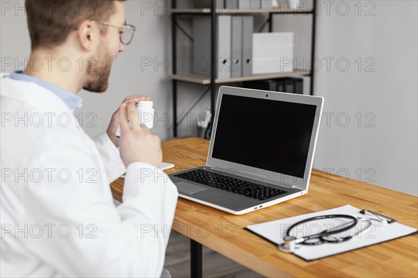 Close up doctor working with laptop