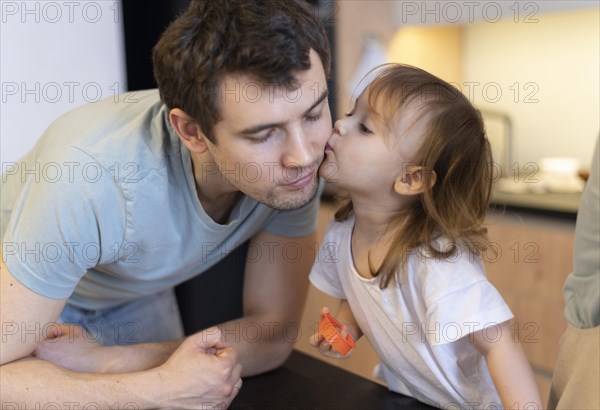 Close up girl kissing father cheek