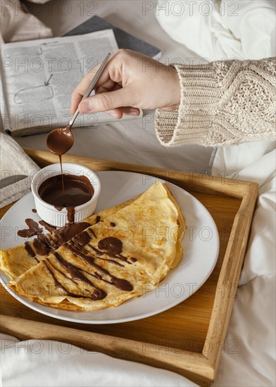 Close up hand holding spoon with chocolate