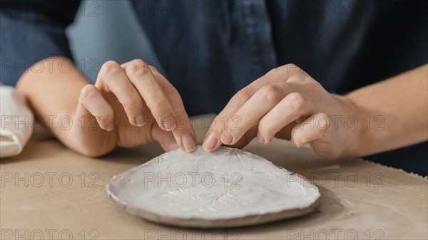 Close up hands holding pottery item