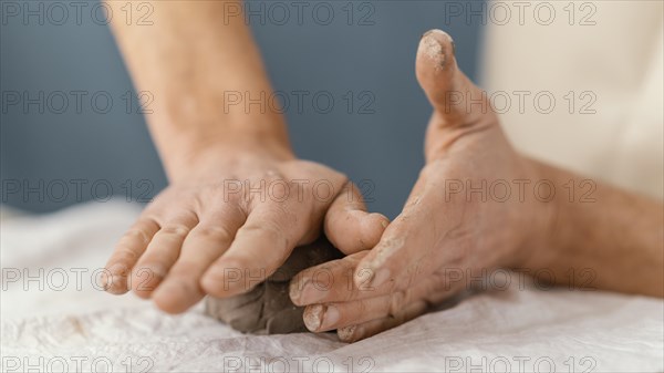 Close up hands shaping clay