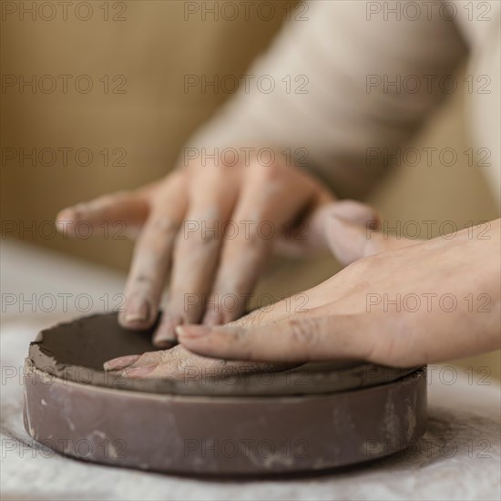 Close up hands touching clay